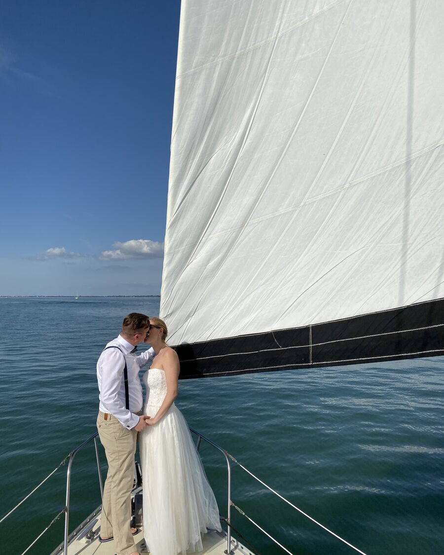 Una pareja en la proa del Key Breeze a toda vela en un paseo por la tarde