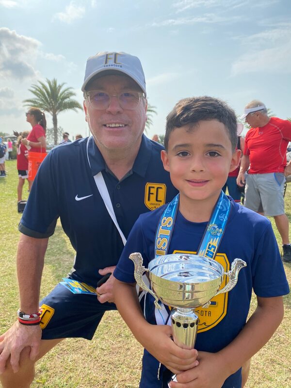 A grandson with his soccer tournament cup